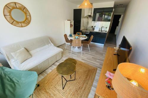 un salon avec un canapé et une table dans l'établissement Sérénité - Appartement une chambre proche de la plage, à La Grande Motte