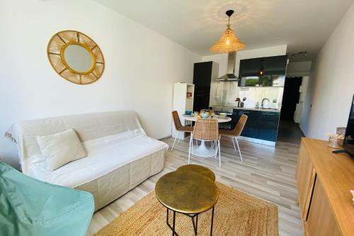 un salon avec un canapé blanc et une table dans l'établissement Sérénité - Appartement une chambre proche de la plage, à La Grande Motte