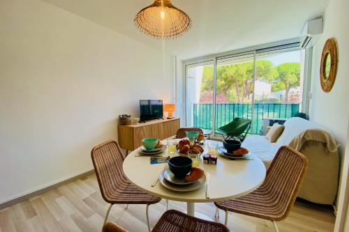 une salle à manger avec une table et des chaises et une fenêtre dans l'établissement Sérénité - Appartement une chambre proche de la plage, à La Grande Motte