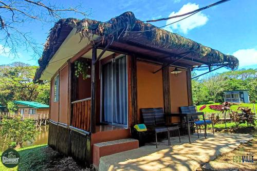 a small house with a porch and a table at Caliraya Ecoville Recreation and Farm Resort in Cavinti