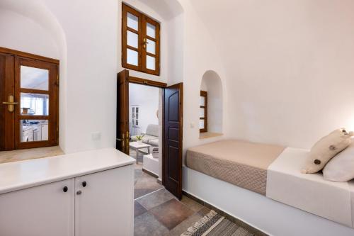 a white bedroom with a bed and a mirror at Canaves Karterados - Hermes in Karterados