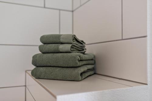 a stack of green towels sitting on a shelf in a bathroom at Haus Bergruh Kuckucksnest in Todtnauberg