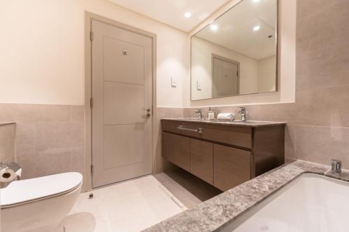 a bathroom with a sink and a toilet and a mirror at Fabulous 2BR high floor luxury apartment with Burj Khalifa view in Dubai