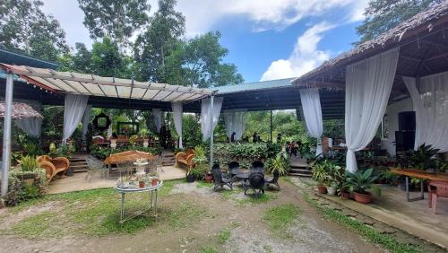 a patio with a bunch of tables and chairs at Paglinawan Organic Eco Farm in Molave