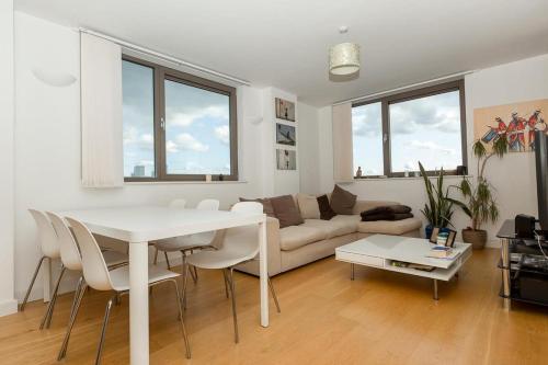 sala de estar con mesa blanca y sofá en 2 Bedroom East London Apartment With Amazing Views, en Londres