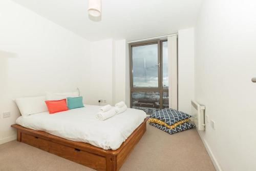 1 dormitorio con cama y ventana en 2 Bedroom East London Apartment With Amazing Views, en Londres