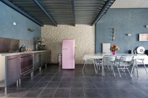 eine Küche mit einem rosa Kühlschrank und einem Tisch in der Unterkunft Logis de Carantonus in Saint-Jean-de-Liversay