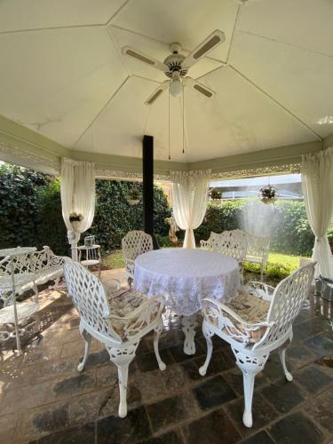 a white table with chairs and a ceiling fan at Garden Court in Potchefstroom
