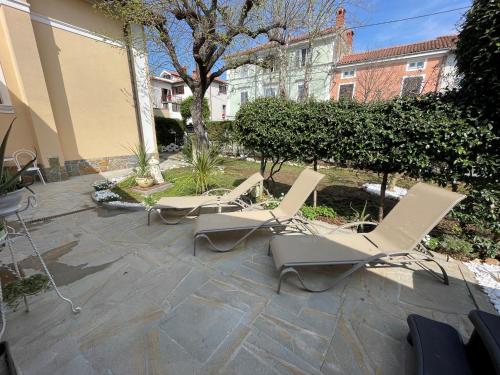 a group of chairs sitting on a patio at Villa Noa jacuzzi & sauna in Izola