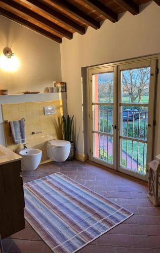 a bathroom with two toilets and a large window at My Tuscany Relais in Altopascio