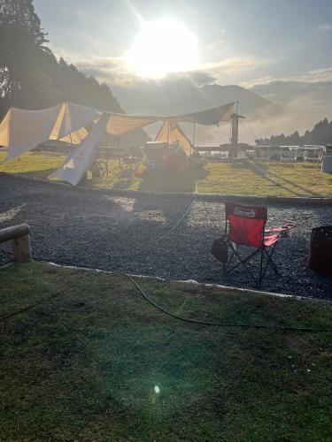 a red chair and a tent and a plane at パワースポットキャンプ場 in Shimoda
