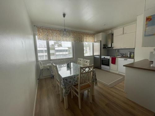 a kitchen with a table and chairs and a kitchen with white cabinets at Kempele city center in Kempele