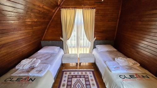 dwa łóżka w pokoju z oknem w obiekcie Zeyve Bungalov Tatil Köyü w mieście Karaman