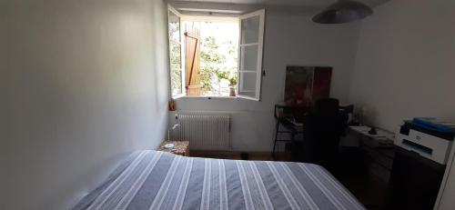 une chambre avec un lit et une fenêtre dans l'établissement MAISON VUE MAGISTRALE SUR LE PORT ET CALANQUES DES GOUDES MARSEILLE, à Marseille