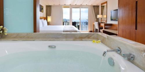 ein Badezimmer mit Badewanne in einem Hotelzimmer in der Unterkunft Fullon Resort Kending in Eluan