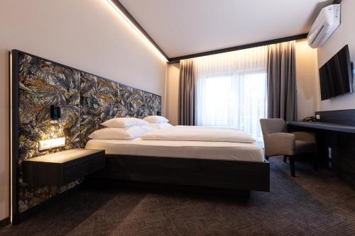 a hotel room with a large bed and a desk at Thermalhotel Leitner in Loipersdorf bei Fürstenfeld