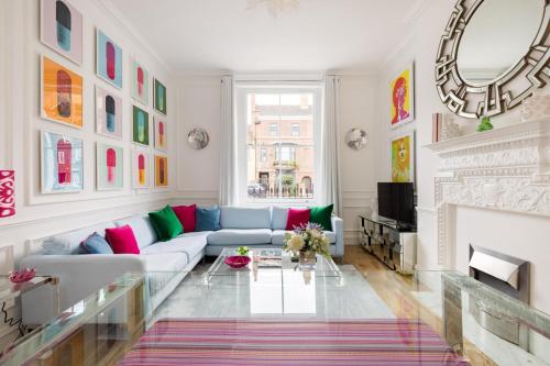 a living room with a couch and a fireplace at Cosy and Stylish Chelsea 2 bedroom flat in London