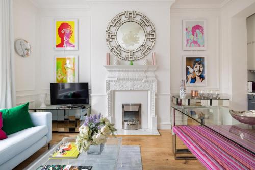 a living room with a fireplace and a large clock on the wall at Cosy and Stylish Chelsea 2 bedroom flat in London