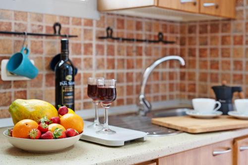 a bowl of fruit and a glass of wine on a kitchen counter at House in Anaga in Almáciga