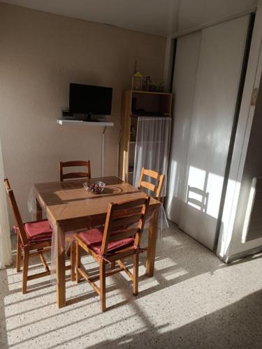 une salle à manger avec une table et quatre chaises dans l'établissement BALARUC FAMILLE, à Balaruc-les-Bains