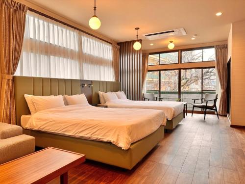 a hotel room with two beds and a window at KOUBOUNOYU HONTEN in Shizuoka