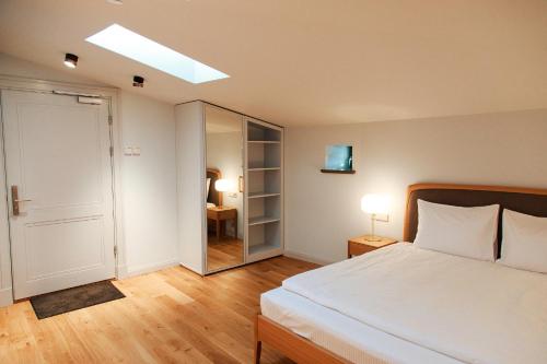 a bedroom with a white bed and a mirror at Roze Center Apartments in Liepāja