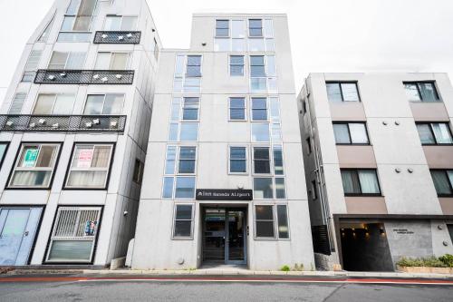 un edificio blanco alto con una puerta en la parte delantera en Minn Haneda Airport, en Tokio