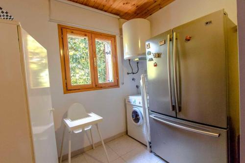 a kitchen with a refrigerator and a washing machine at Swiss style villa near Barcelona 10min to beach in Sant Cebrià de Vallalta