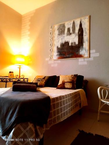 a bedroom with a bed and a painting on the wall at Casapatrizia Appartamento compartido in Santa Cruz de Tenerife