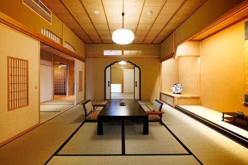 um hall com uma mesa e cadeiras num quarto em Shoraiso em Yamanouchi