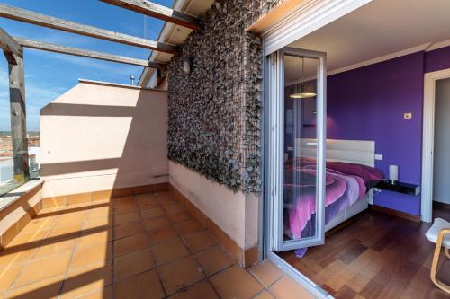 une chambre avec des murs violets et un lit avec une fenêtre dans l'établissement Ático Fray Toribio, à Zamora