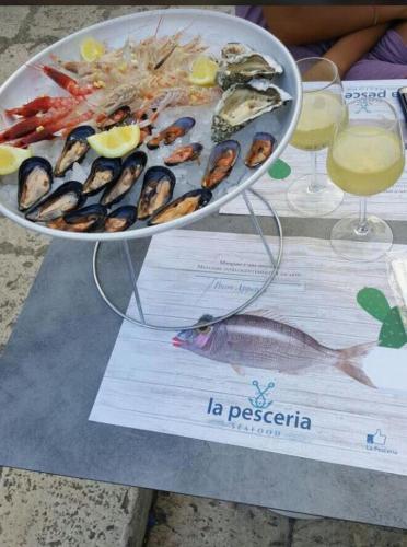 un plato de marisco en una mesa con copas de vino en Casa Madama, en Castro di Lecce