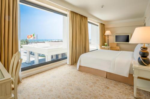 a hotel room with a bed and a large window at The Kingsbury Colombo in Colombo