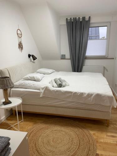 ein weißes Bett in einem Zimmer mit Fenster in der Unterkunft Ferienwohnung in Weitersburg