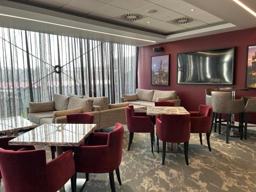 a room with a couch and tables and chairs at Tynecastle Park Hotel in Edinburgh