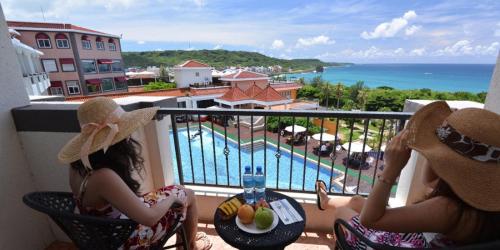 two women sitting on a balcony looking out at the ocean at Fullon Resort Kending in Eluan