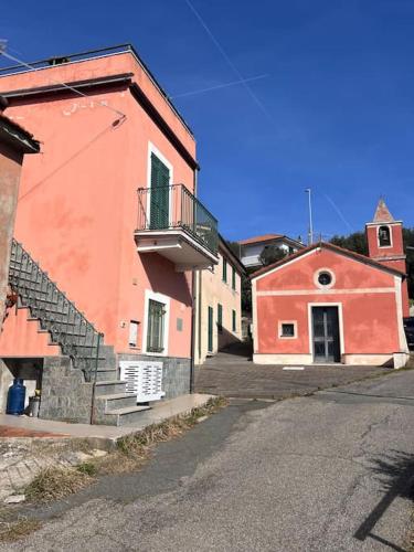 a red building with a staircase on the side of a street at Olivetta House Holiday in Moneglia