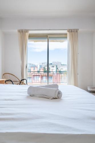une chambre avec un lit blanc avec une grande fenêtre dans l'établissement Magnifique 3P promenade des anglais, à Nice