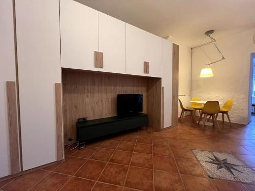 a living room with a television and a table and chairs at Olivetta House Holiday in Moneglia