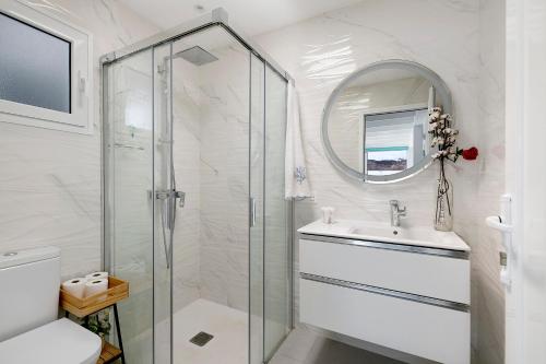 a white bathroom with a shower and a sink at El Pasero in El Golfo