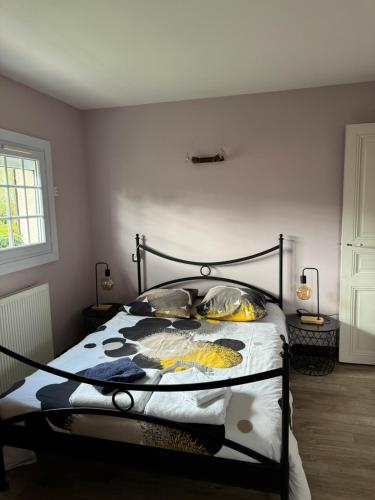 a bedroom with a bed with a black metal frame at les chambres de la grange in Saint-Germain-de-la-Grange