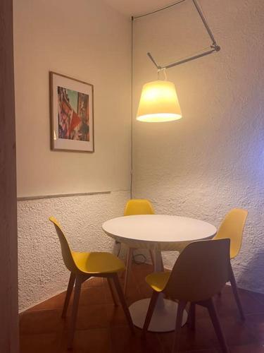 a table with four chairs and a light above it at Olivetta House Holiday in Moneglia