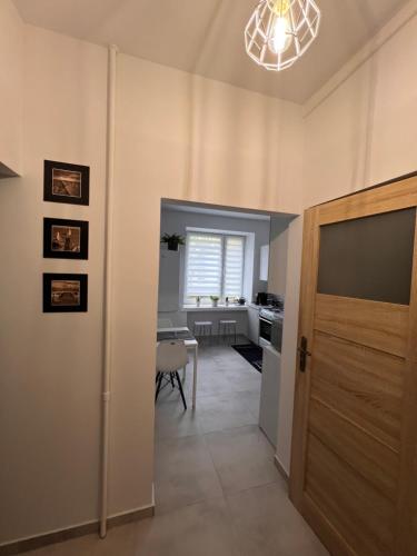 przedpokój z drzwiami i kuchnia ze stołem w obiekcie Apartament Paprotka w mieście Skarżysko-Kamienna