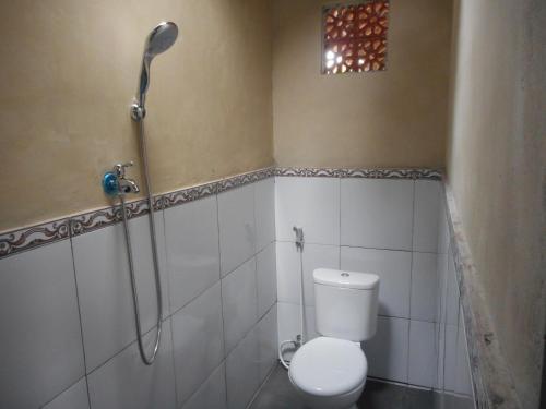 uma casa de banho com um chuveiro e um WC. em Kadek Homestay em Besakih