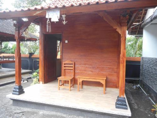 a chair and a bench on a porch of a house at Kadek Homestay in Besakih