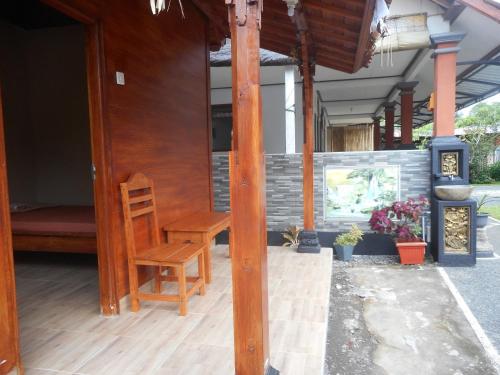 a wooden chair sitting on the porch of a house at Kadek Homestay in Besakih