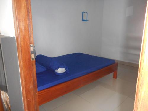 a small bed with a blue sheet on it at Kadek Homestay in Besakih