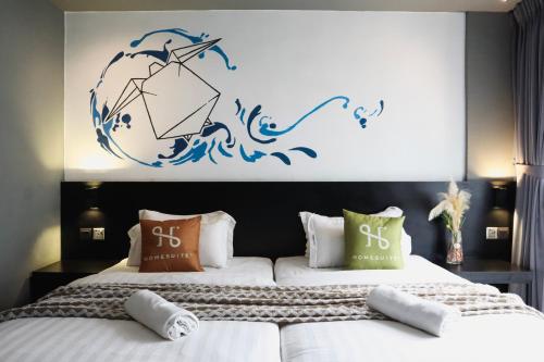 two beds in a bedroom with a blue wall at Homesuite' Home at Aeropod SOVO in Kota Kinabalu