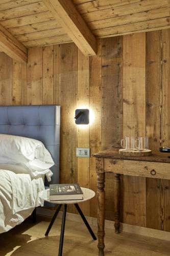 a bedroom with a bed and a table with a table sidx sidx sidx at Locanda Boton D'Oro in Auronzo di Cadore