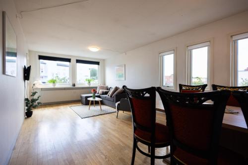 salon z krzesłami, kanapą i oknami w obiekcie Søpark Apartments w mieście Maribo